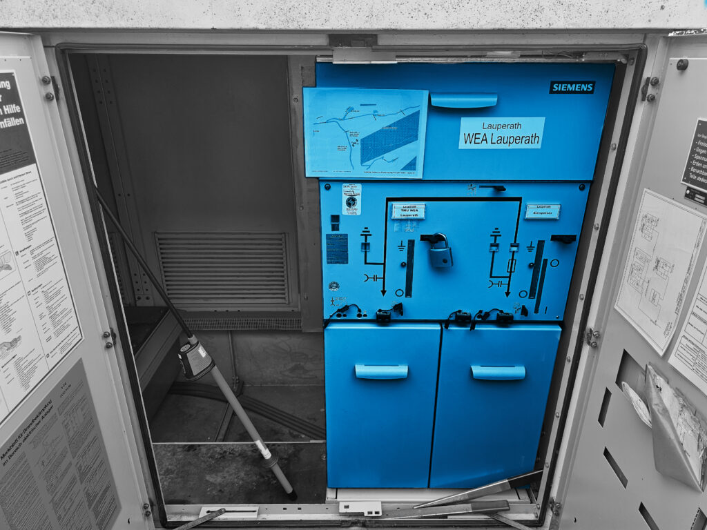 Offener Schaltschrank mit blauem Siemens‑Steuergerät.